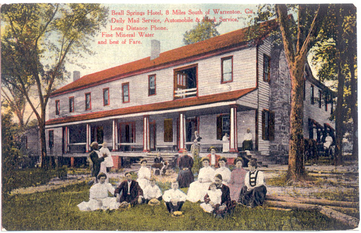 Photo postcard showing a large two-story frame building with a long veranda.  A dozen people in formal summer attire are posed on the lawn in front of the building. Printed over the photo are the words "Beall Springs Hotel, 8 Miles South of Warrenton, Ga. Daily Mail Service, Automobile and Hack Service, Long Distance Phone, Fine Mineral Water and best of Fare."